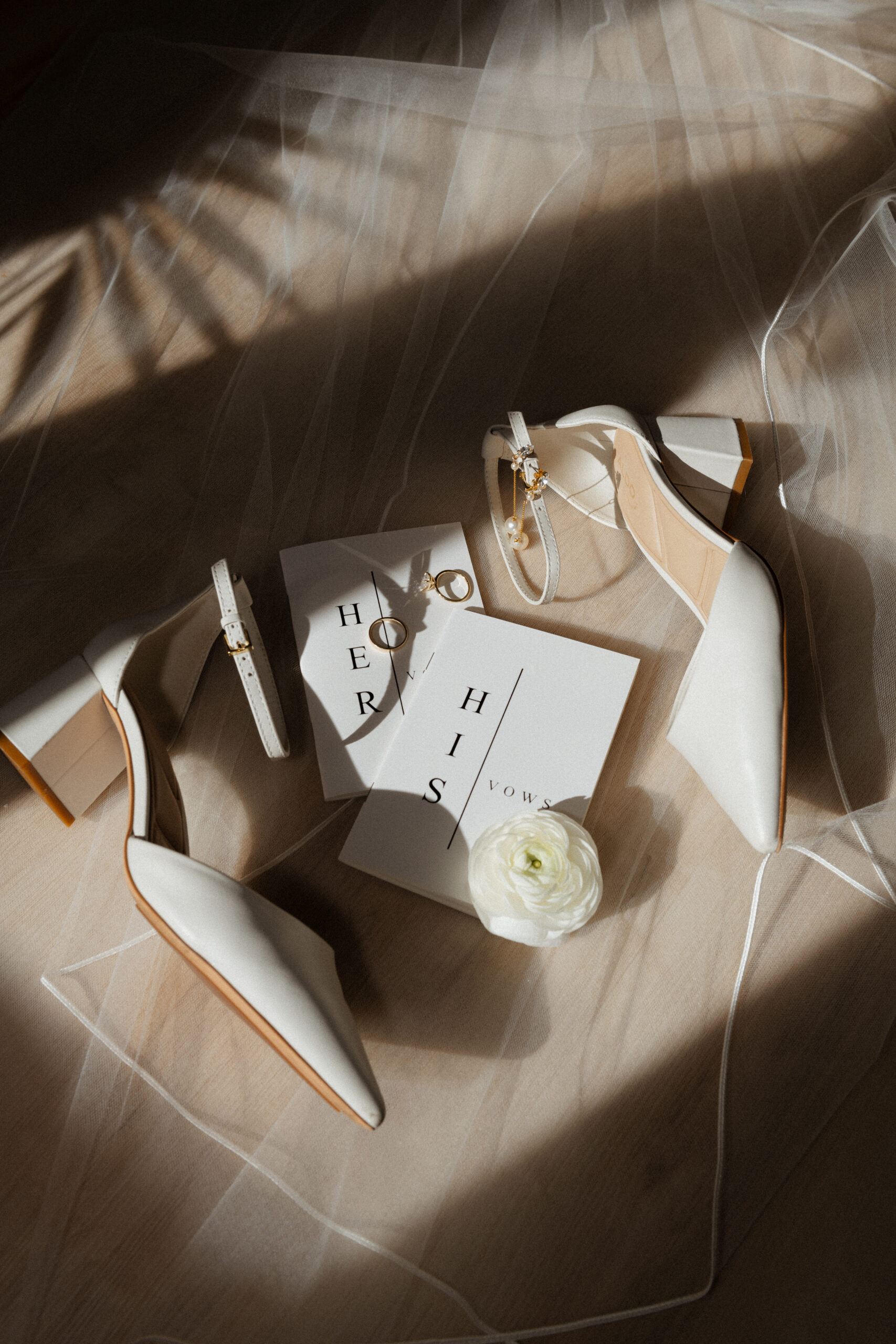 Flatlay with a veil, wedding shoes, and vow book at The Boathouse in Ottawa, by Chelsea Gurr Photography.