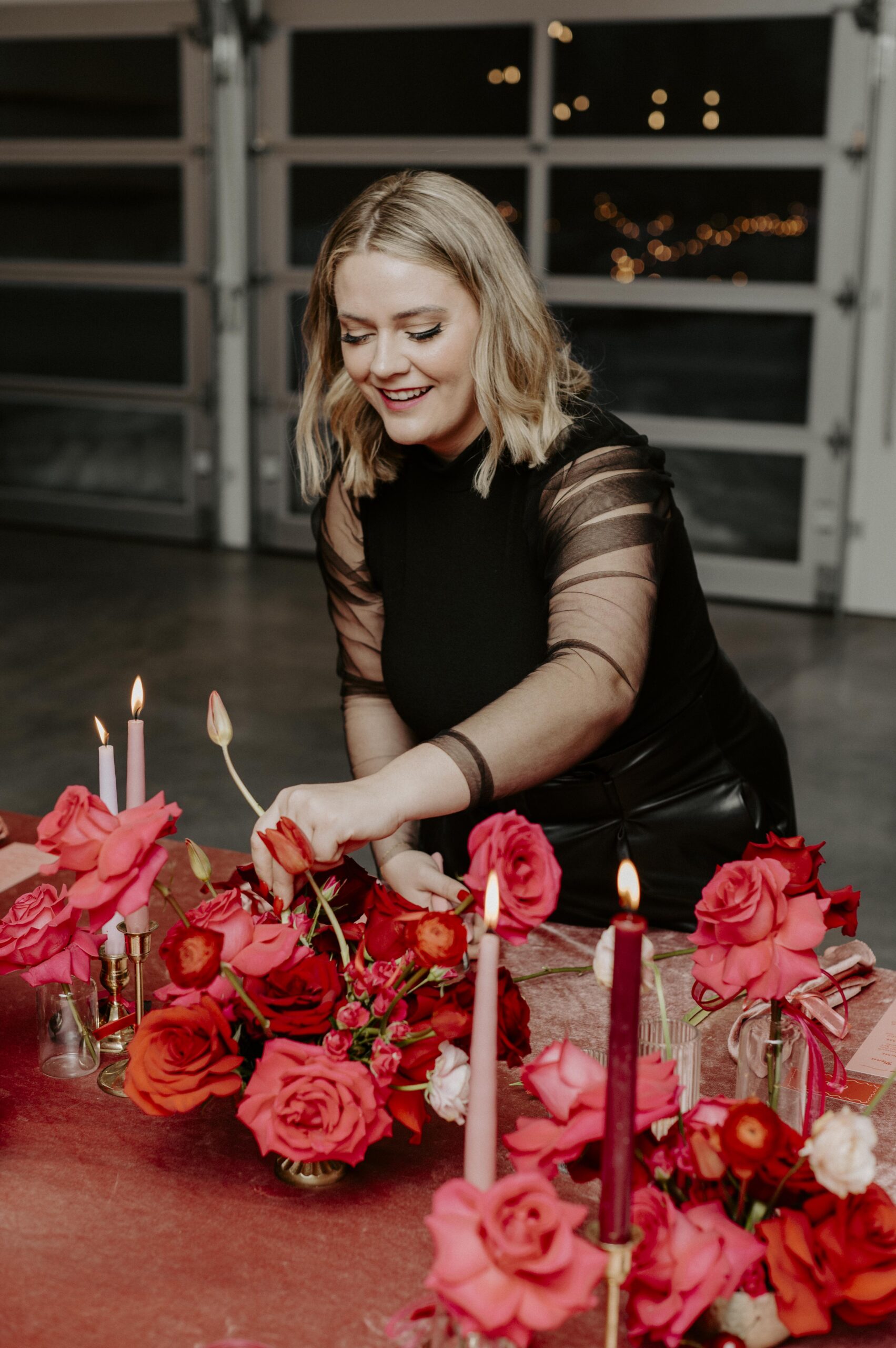 Brittany Bested, owner of Wild Bloem Studios, setting up a wedding tablescape, captured by Danielle McFaul Photography.