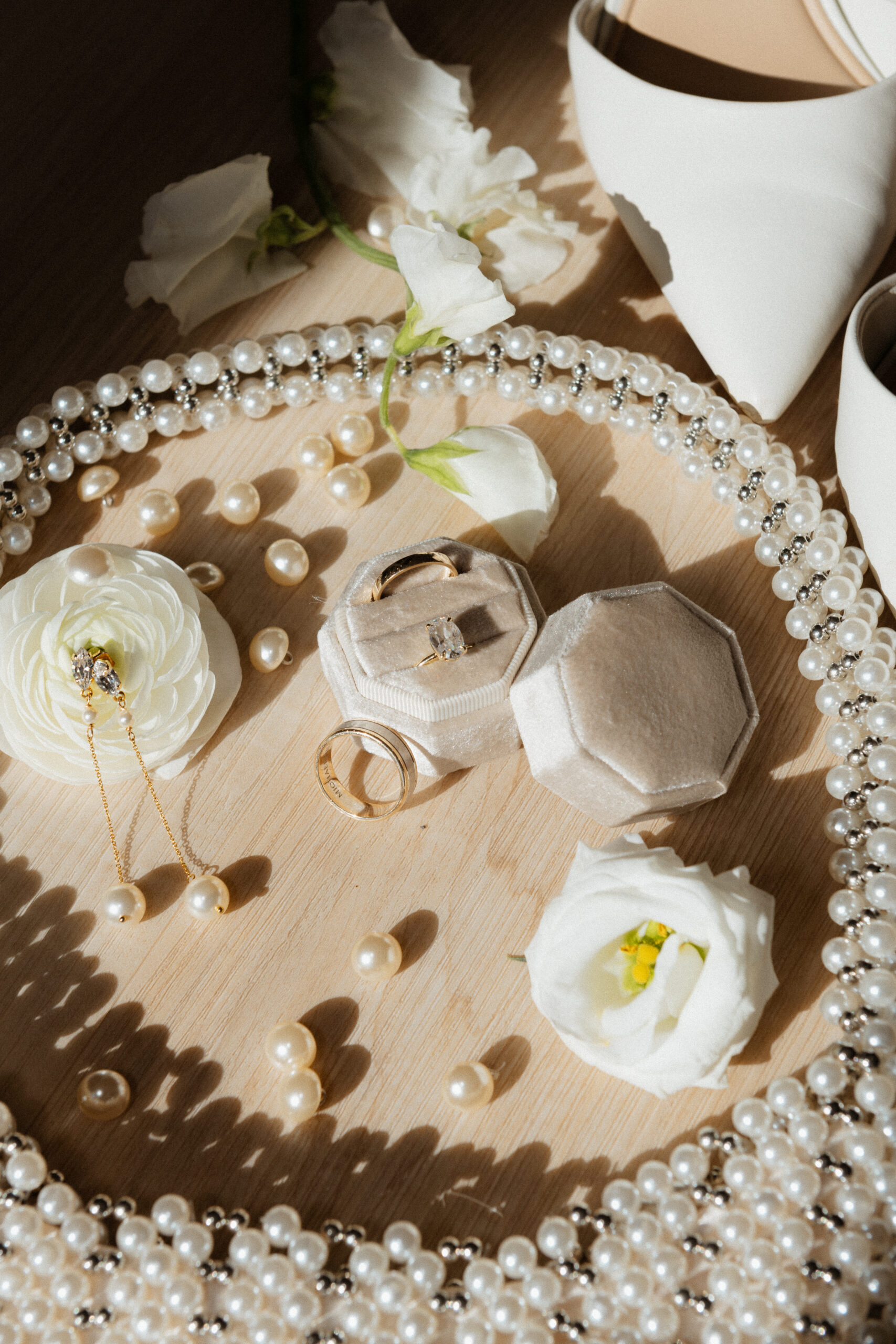 Elegant flat lay featuring a purse, earrings, and floral elements for wedding goals