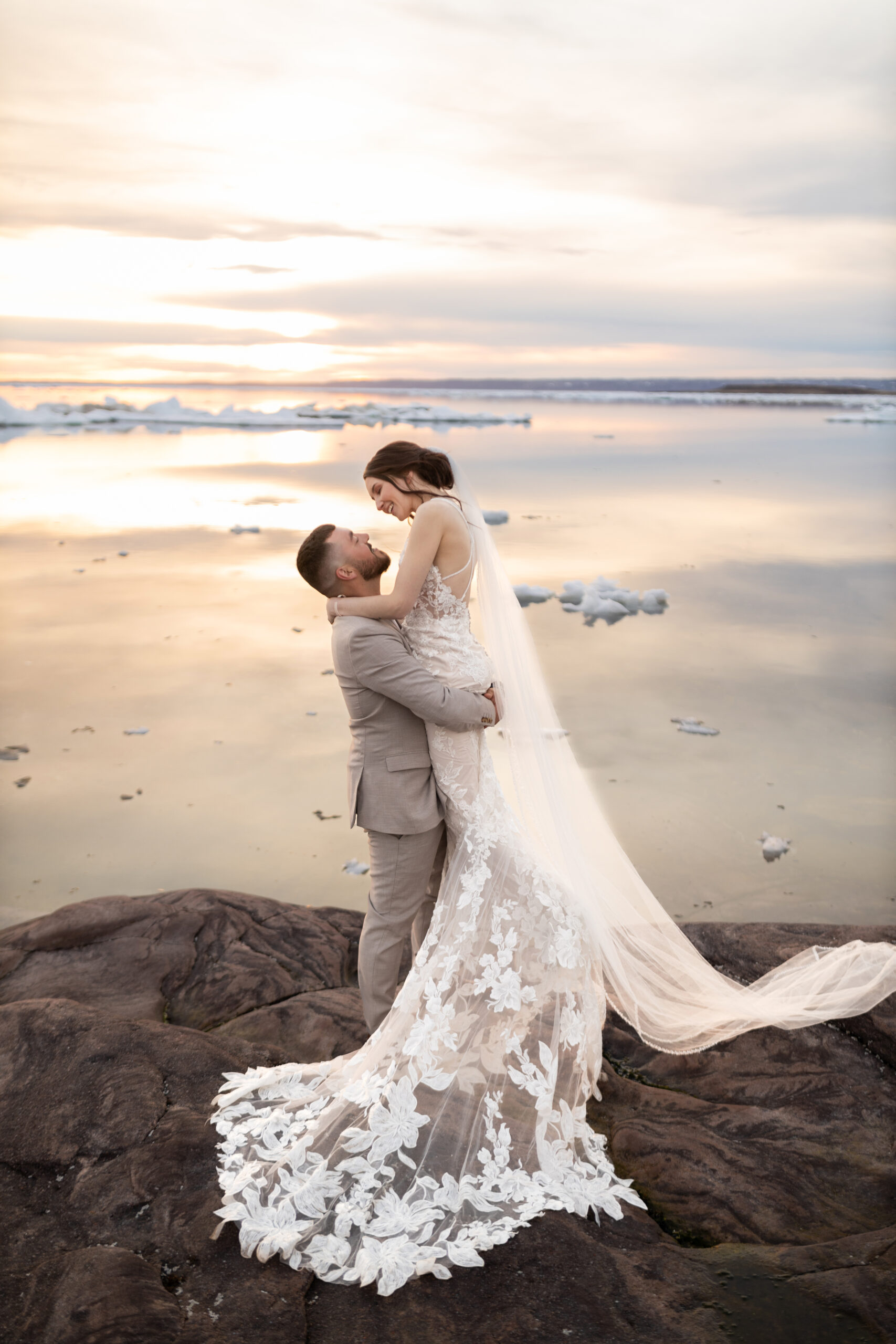 Newlywed couple taking wedding photos in front of iceberg on their perfect wedding day